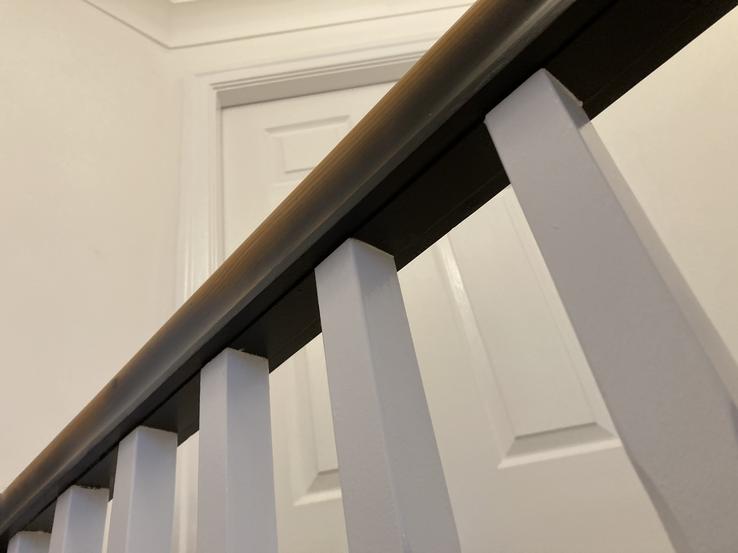 well painted black handrail with white spindles